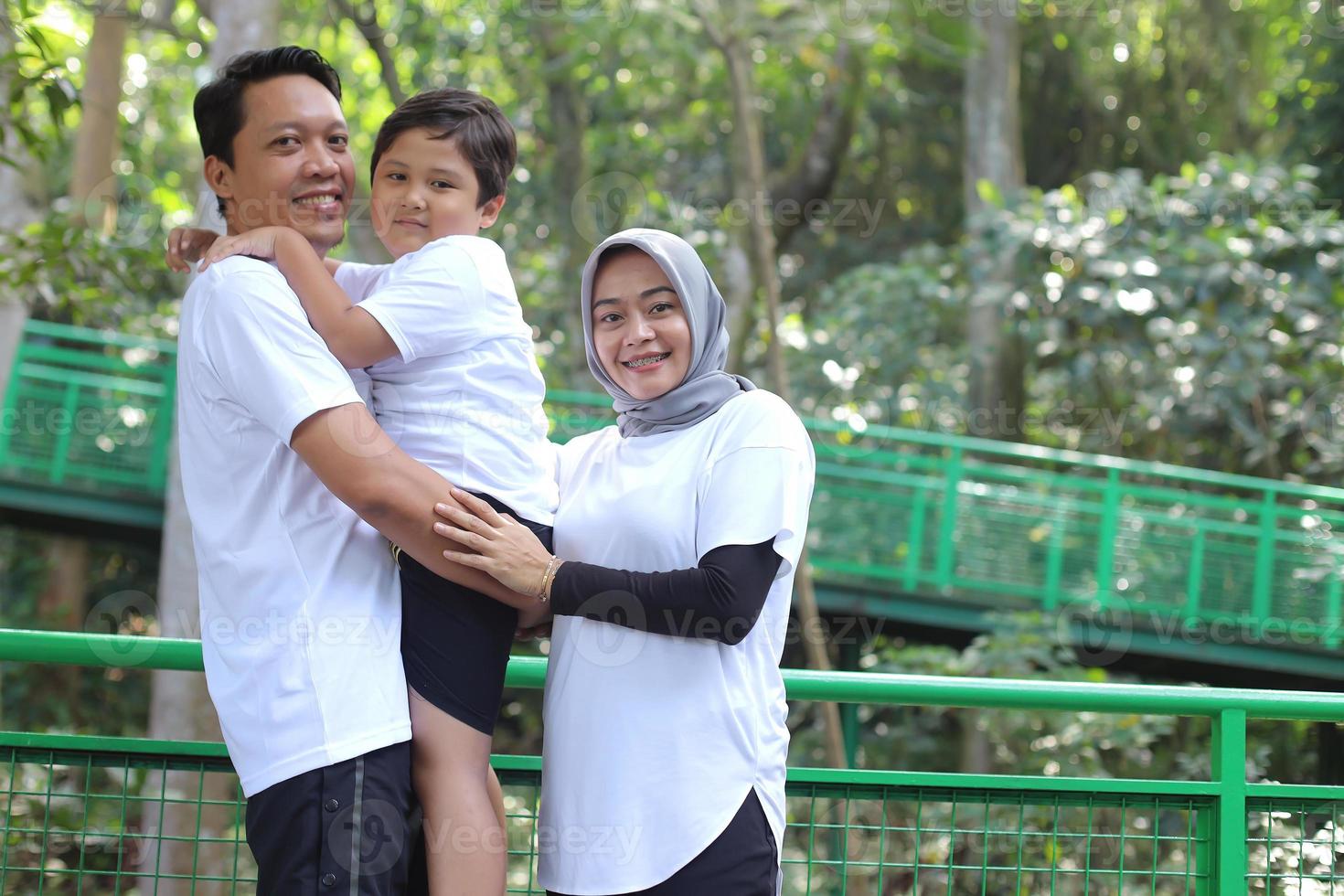 Young happy family of three having fun together outdoor. Father holding son look happy and smile. Happiness and harmony in family life. Family fun outside. photo