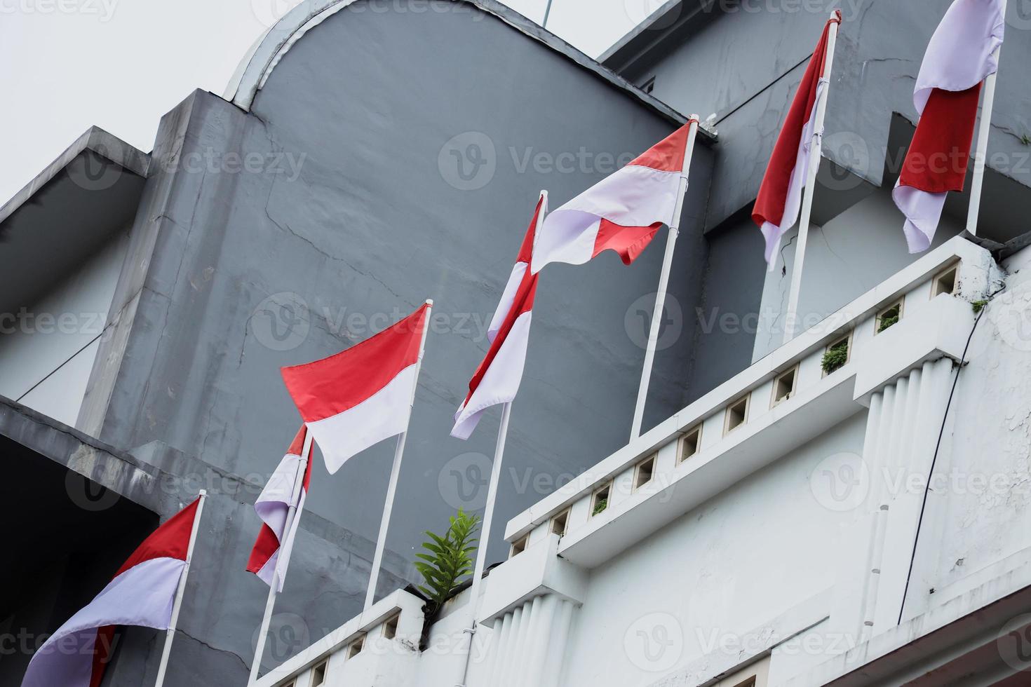Indonesia flags shanging on a terrace of building. Flag raised and blow by the wind. photo