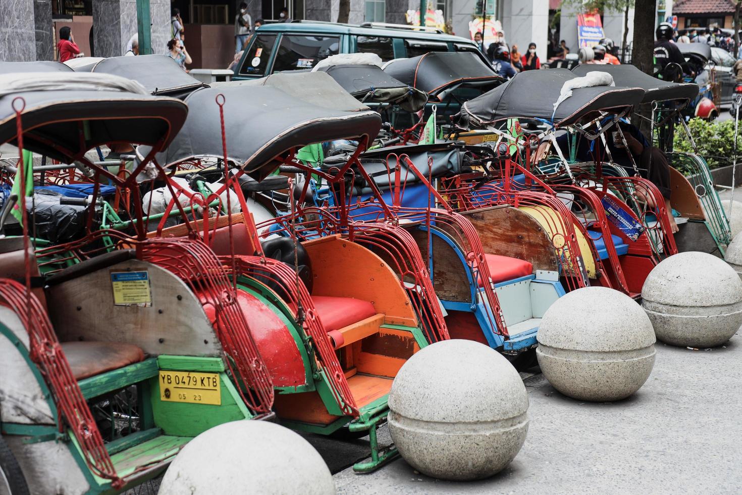 Yogyakarta, Indonesia  May 2022 Becak parked on the road side of Malioboro Street. Becak is  traditional transportation from Java, Indonesia. photo