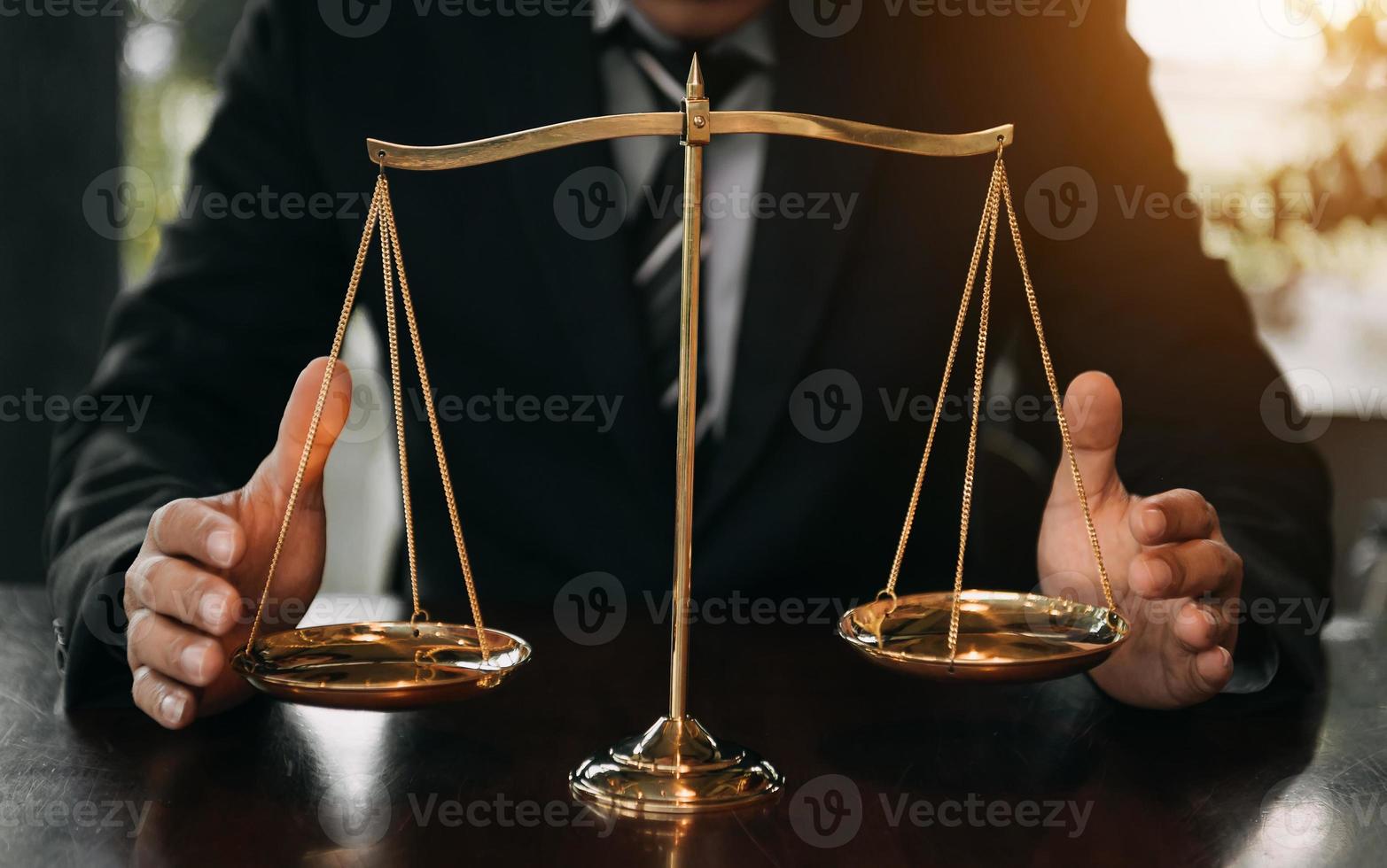 abogado masculino en la oficina con escala de latón sobre mesa de madera. concepto de justicia y derecho foto