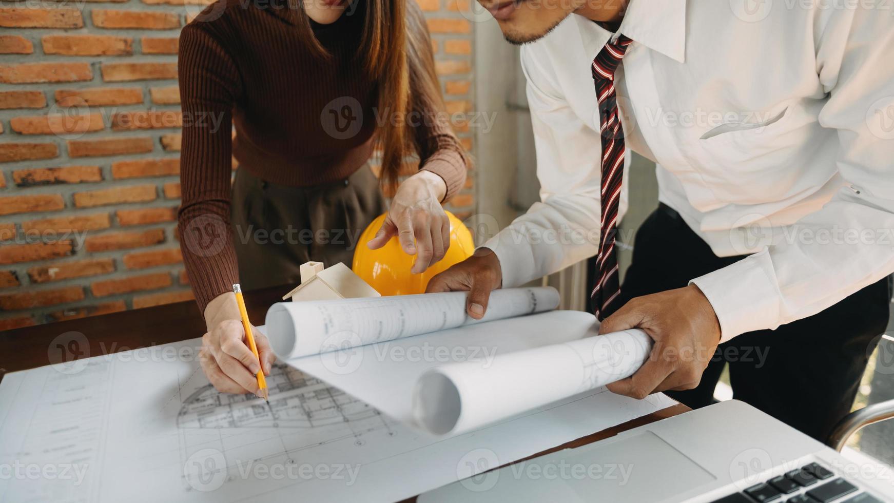 Arquitecto creativo proyectando sobre los grandes dibujos en la oscura oficina loft o cafetería a la luz de la mañana foto