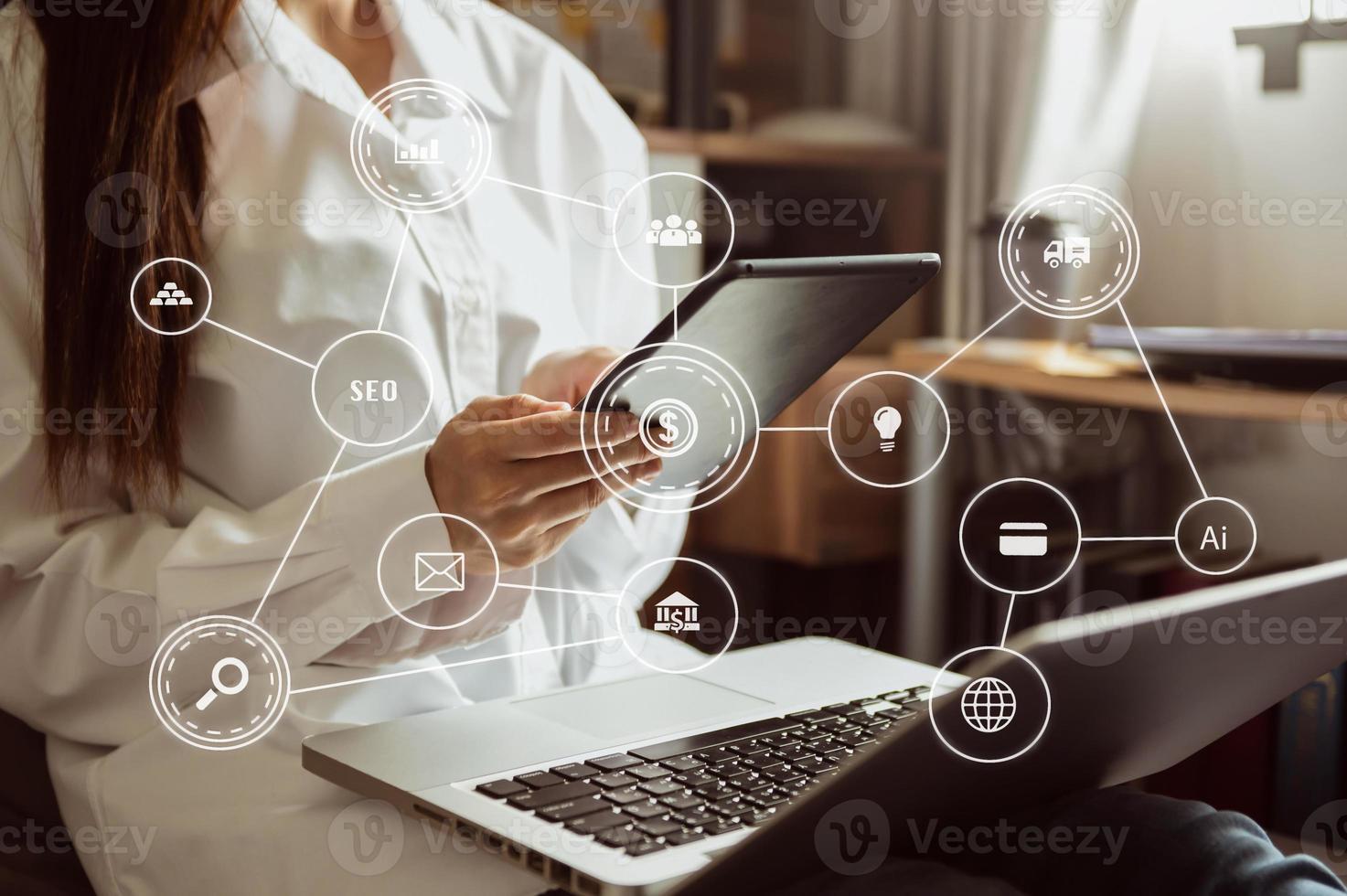 Hands of woman using mobile phone in modern office with laptop and digital tablet computer with VR icon diagram at office photo