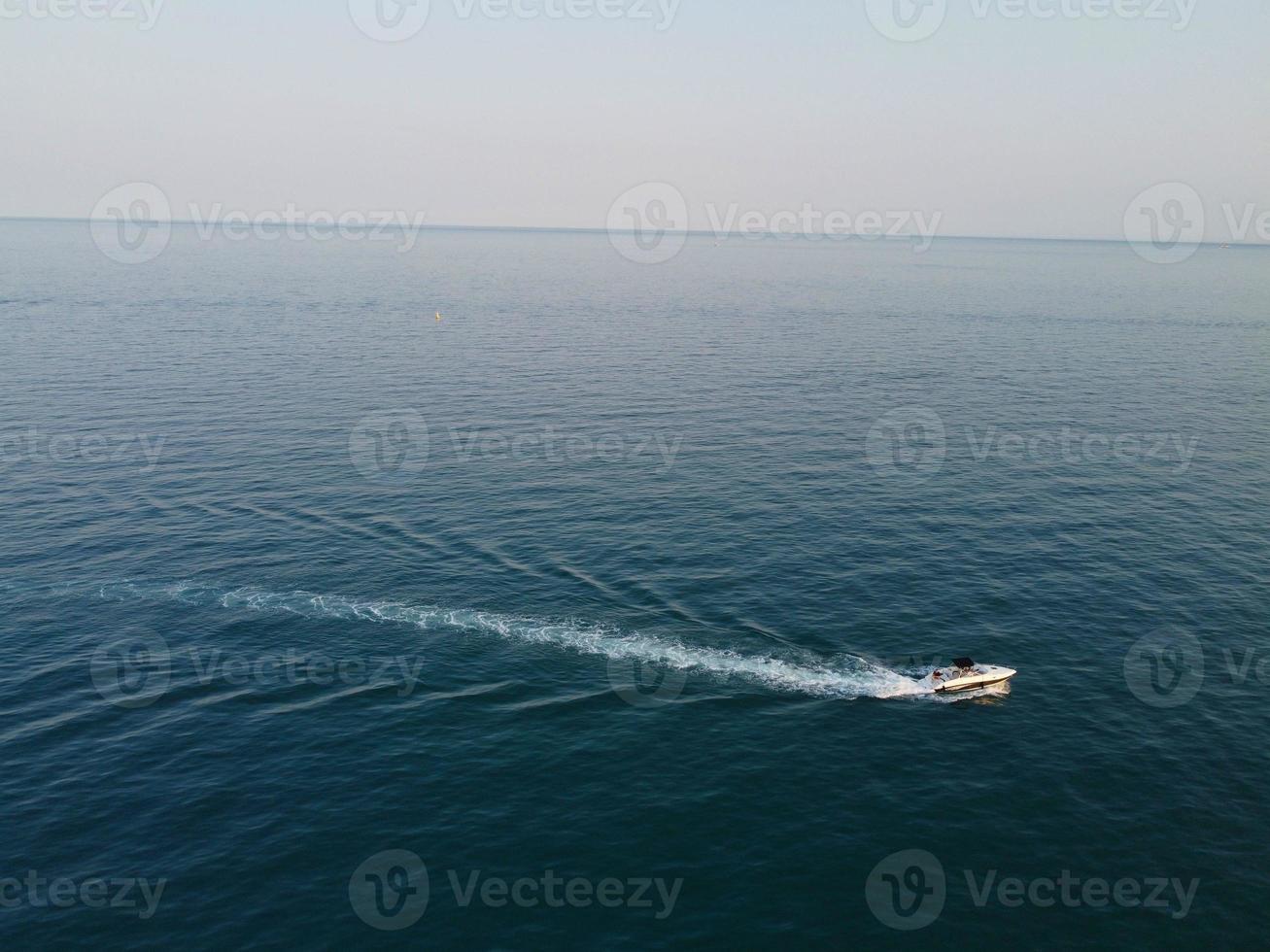 High Angle Footage and Aerial view of Ocean with High Speed Boats, People are having fun and enjoying hottest weather at Bournemouth Beach Sea Front of England UK. photo