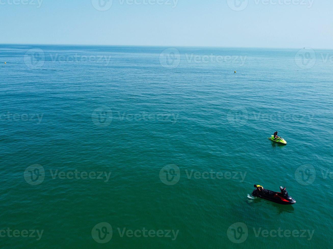 High Angle Footage and Aerial view of Ocean with High Speed Boats, People are having fun and enjoying hottest weather at Bournemouth Beach Sea Front of England UK. photo