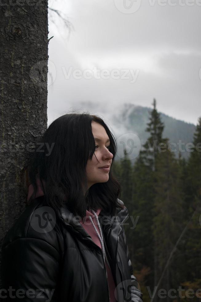 mujer joven en un bosque sombrío con niebla. foto