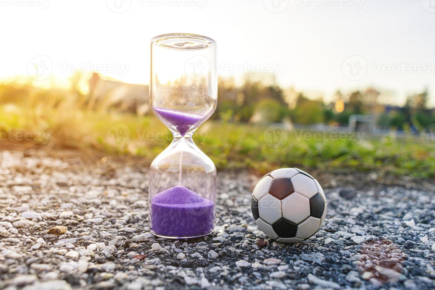 Soccer ball and hourglass symbolizing football time photo