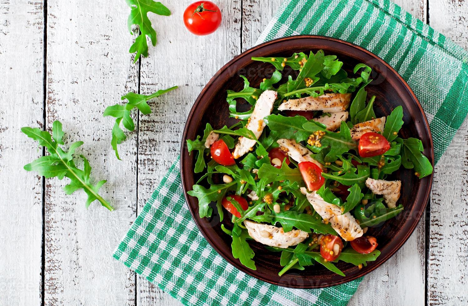 Fresh salad with chicken breast, arugula and tomato photo