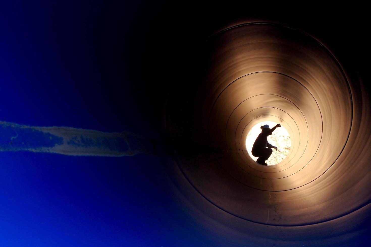A silhouette of a worker in pipe photo