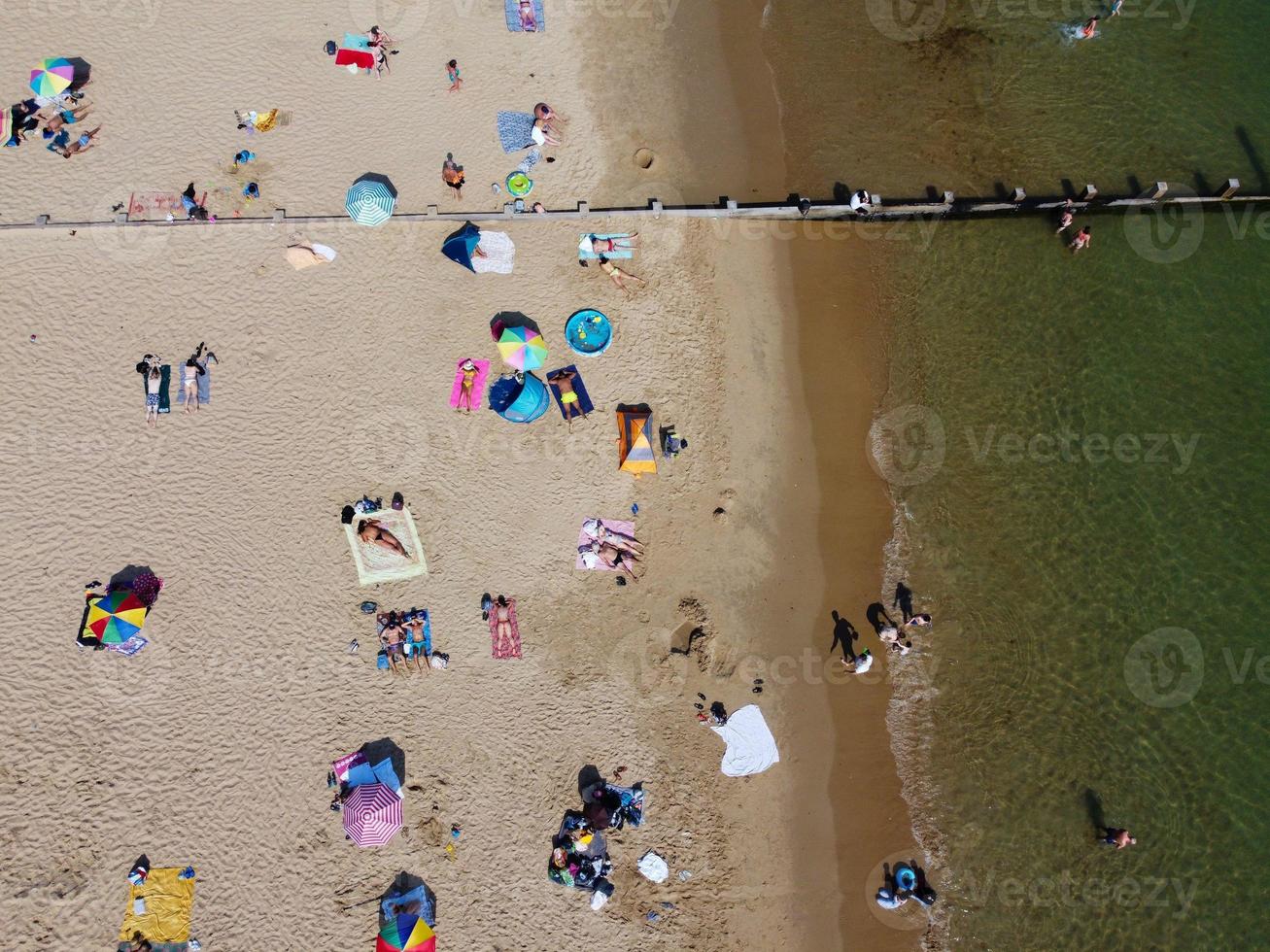 Frente a la playa con vistas al mar en ángulo alto con gente en la ciudad de Bournemouth, Inglaterra, Reino Unido, imágenes aéreas del océano británico foto