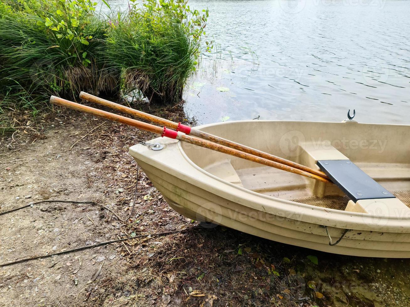 Rowboat lying at the coast of a lake on a sunny day photo