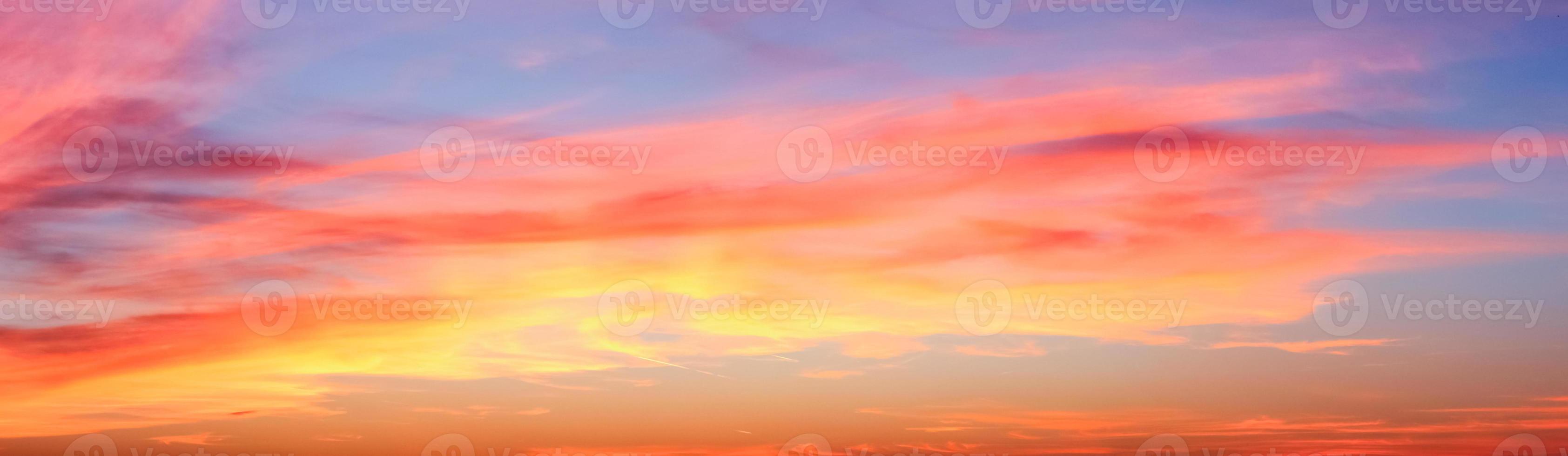 Beautiful high resolution panorama of orange and red sunset clouds in the evening sky photo