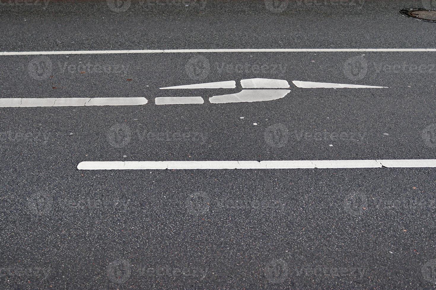 Different signs and marking painted on the ashpalt of streets and roads. photo