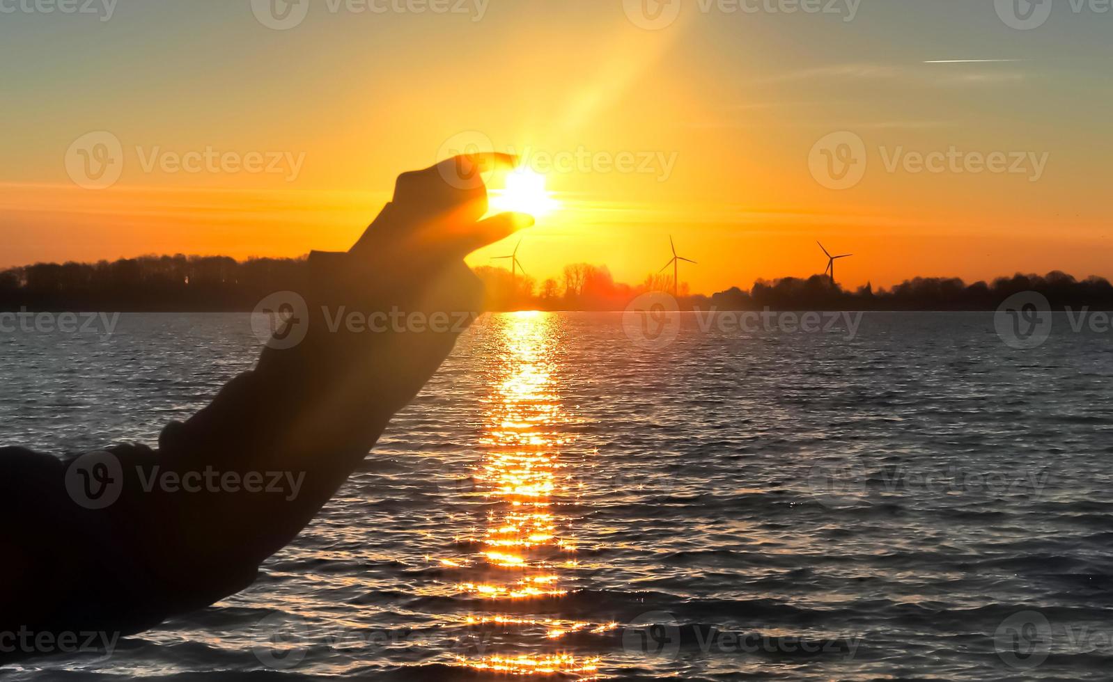 bella y romántica puesta de sol en un lago de colores amarillo y naranja foto