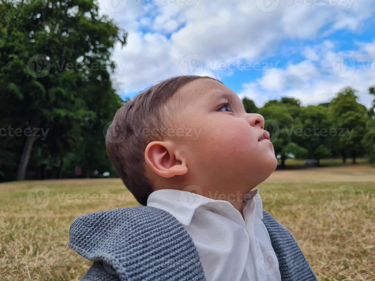 lindo bebé pequeño está posando en un parque público local de la ciudad de luton de inglaterra reino unido foto