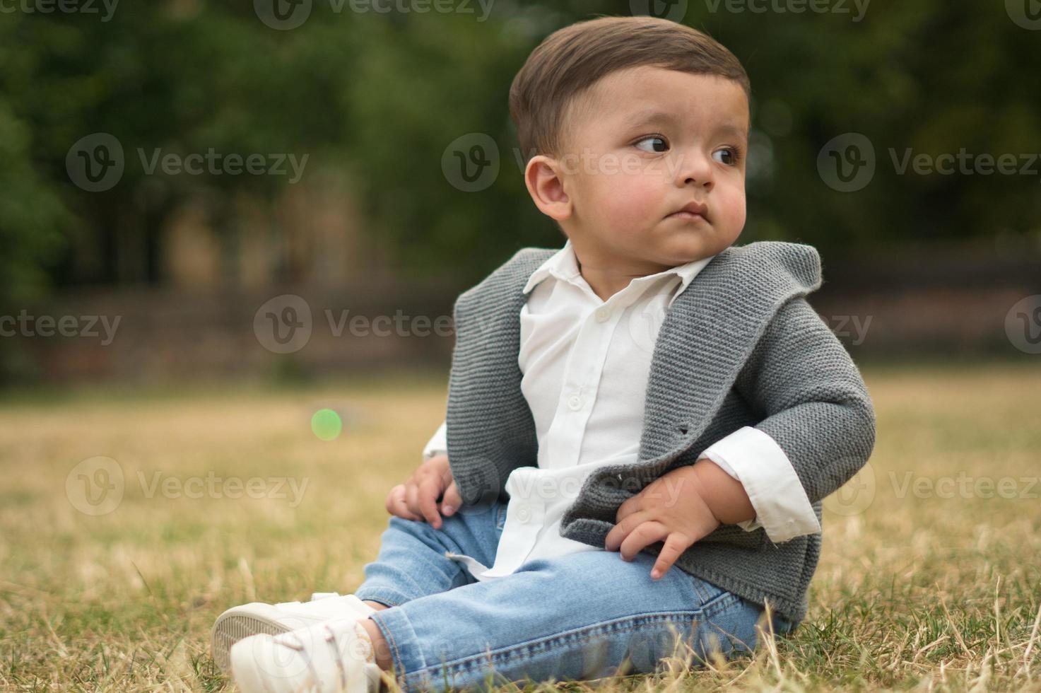 lindo bebé pequeño está posando en un parque público local de la ciudad de luton de inglaterra reino unido foto