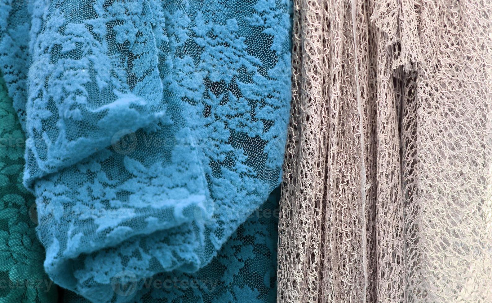 Detailed close up view on samples of cloth and fabrics in different colors found at a fabrics market photo