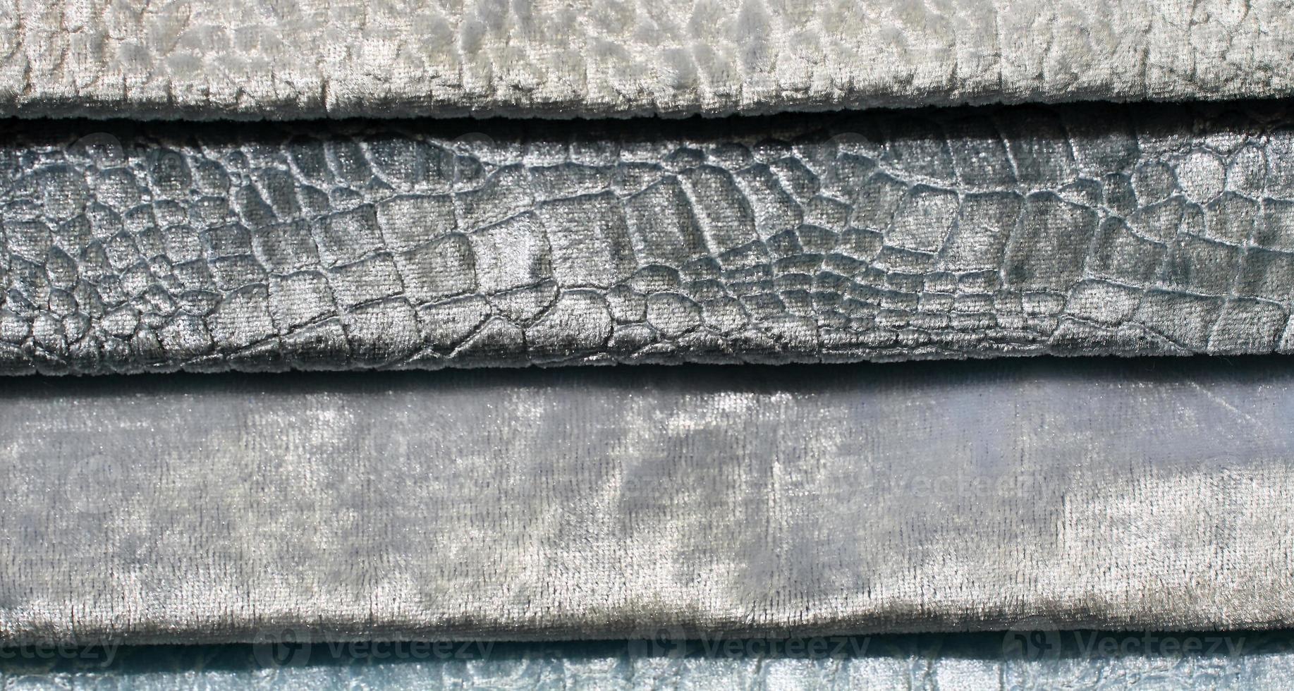 Detailed close up view on samples of cloth and fabrics in different colors found at a fabrics market photo