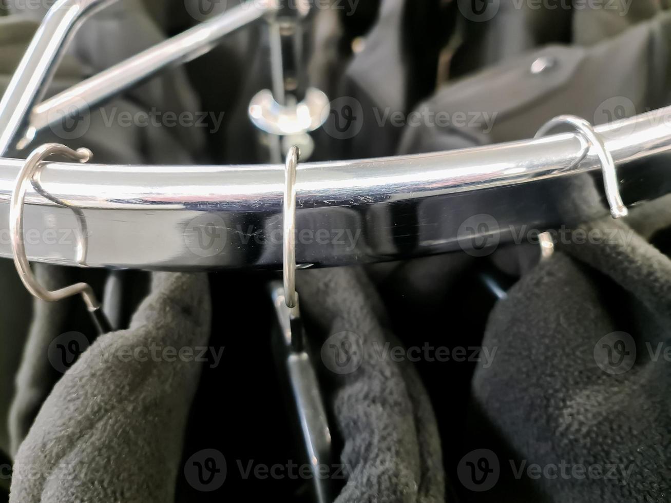 Close up view of several hangers with jackets on them hanging on a clothes rail. photo