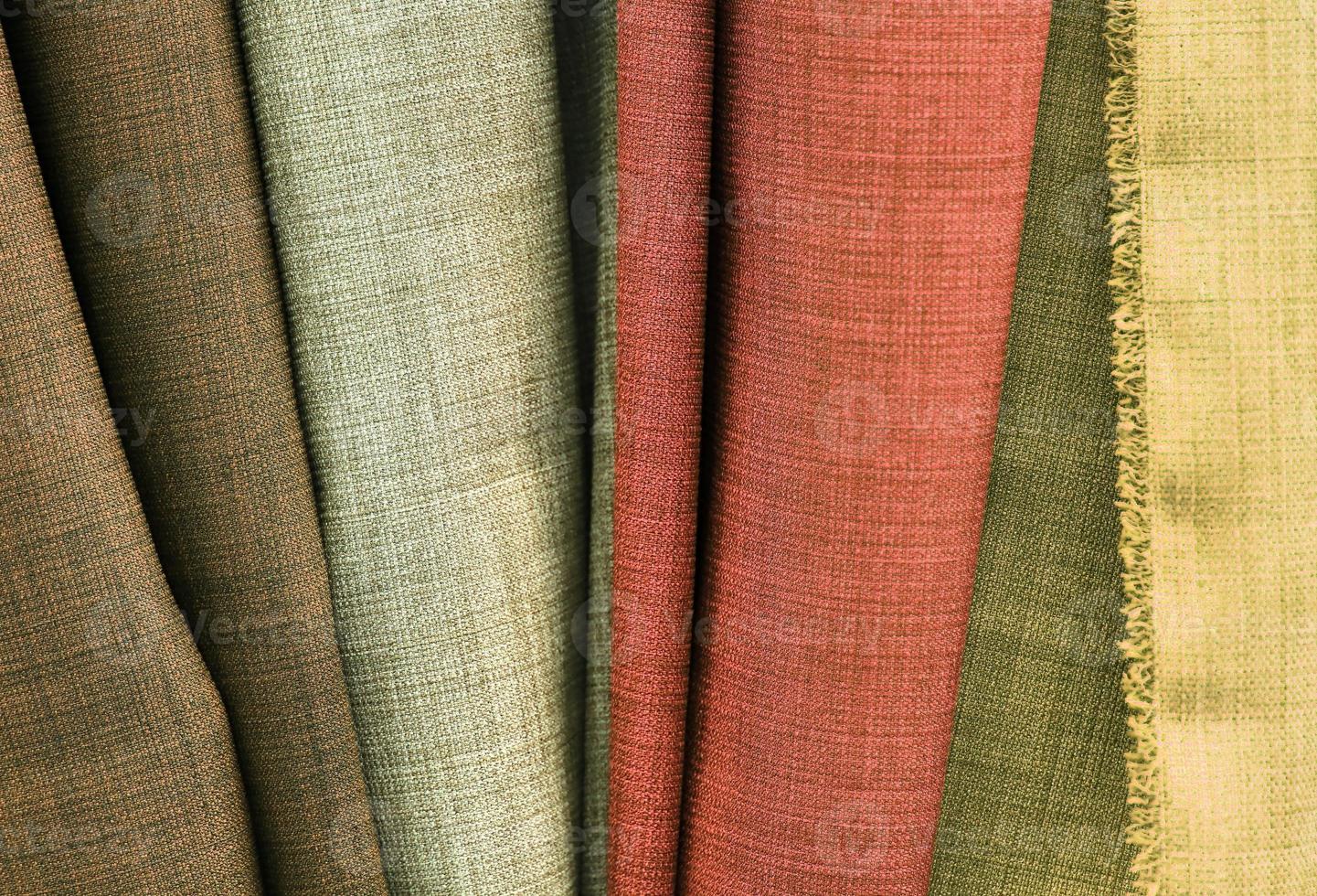 Detailed close up view on samples of cloth and fabrics in different colors found at a fabrics market photo