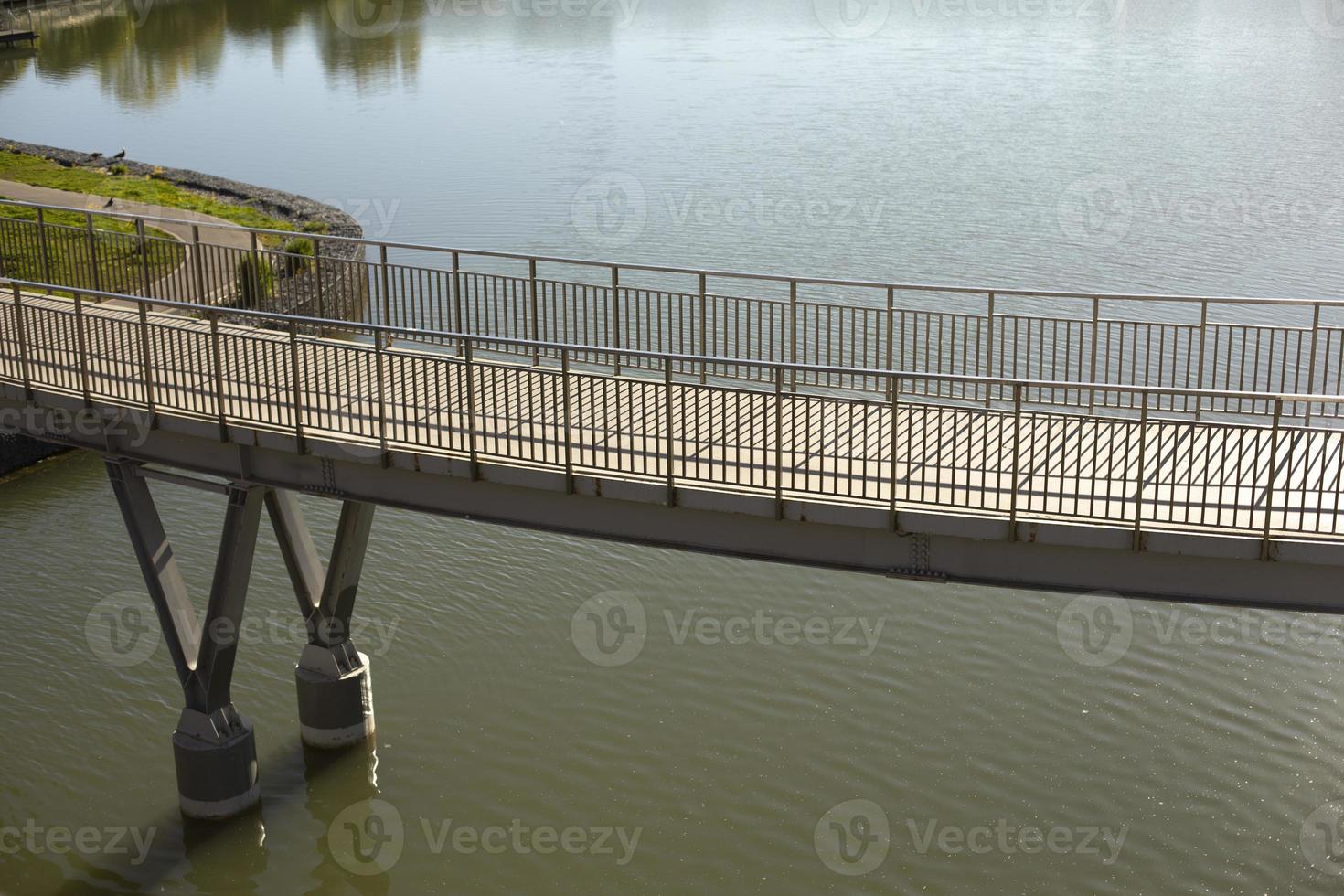 Pedestrian bridge on water. Bridge with railings. Details of park in city. photo