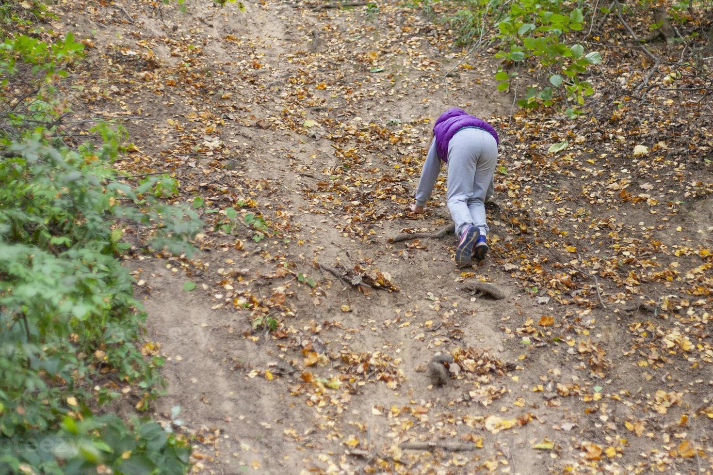 Children climb a hill in the forest. Guys out of town. Childhood in the natural environment. photo