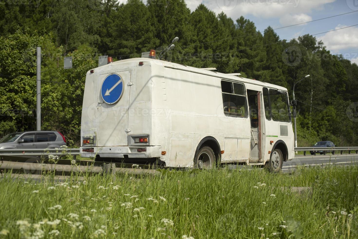 Bus on road with signal lights. Maintenance of road. photo