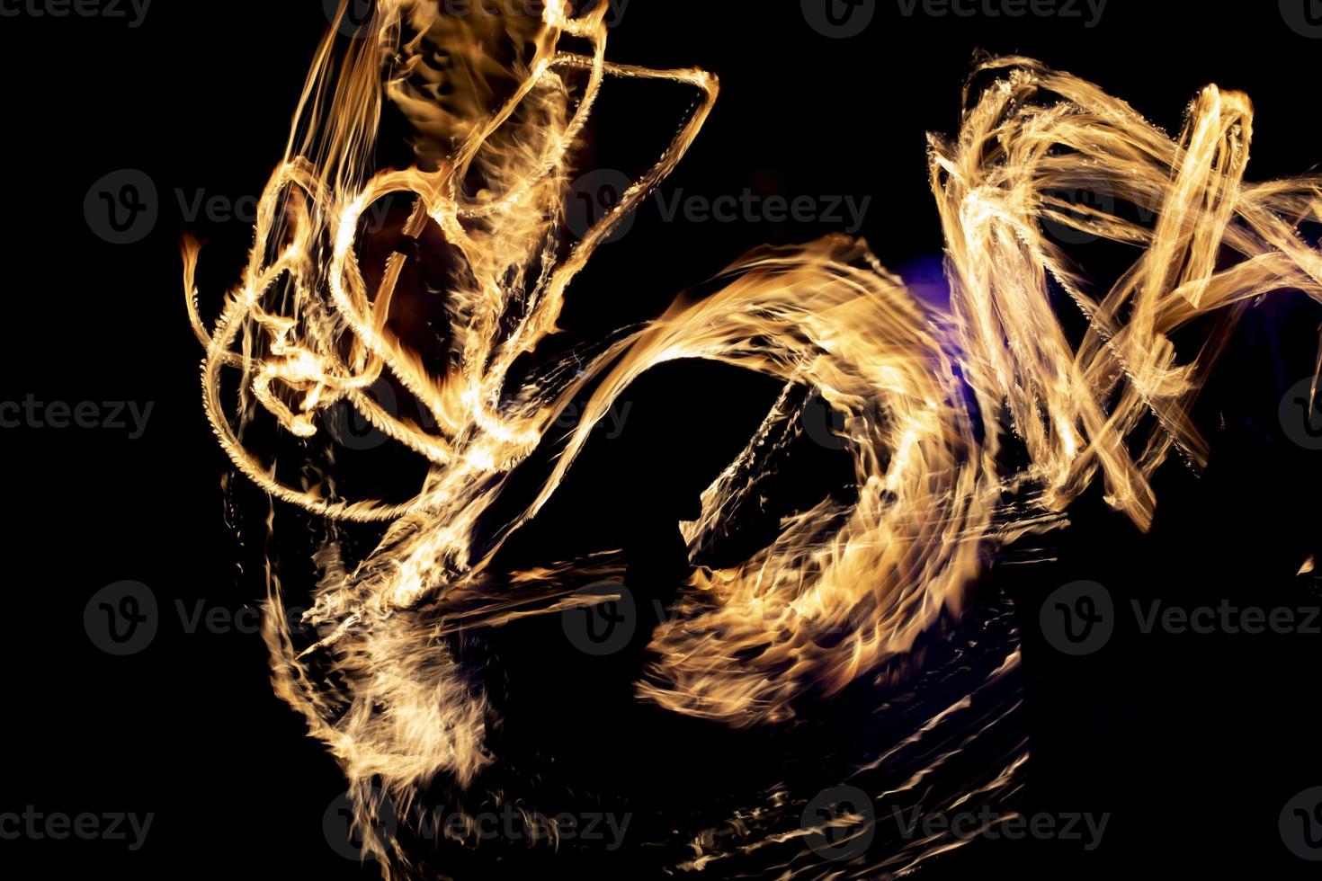 Fire in dark. Fire show at night. Chaotic flames. Lines of fire. photo