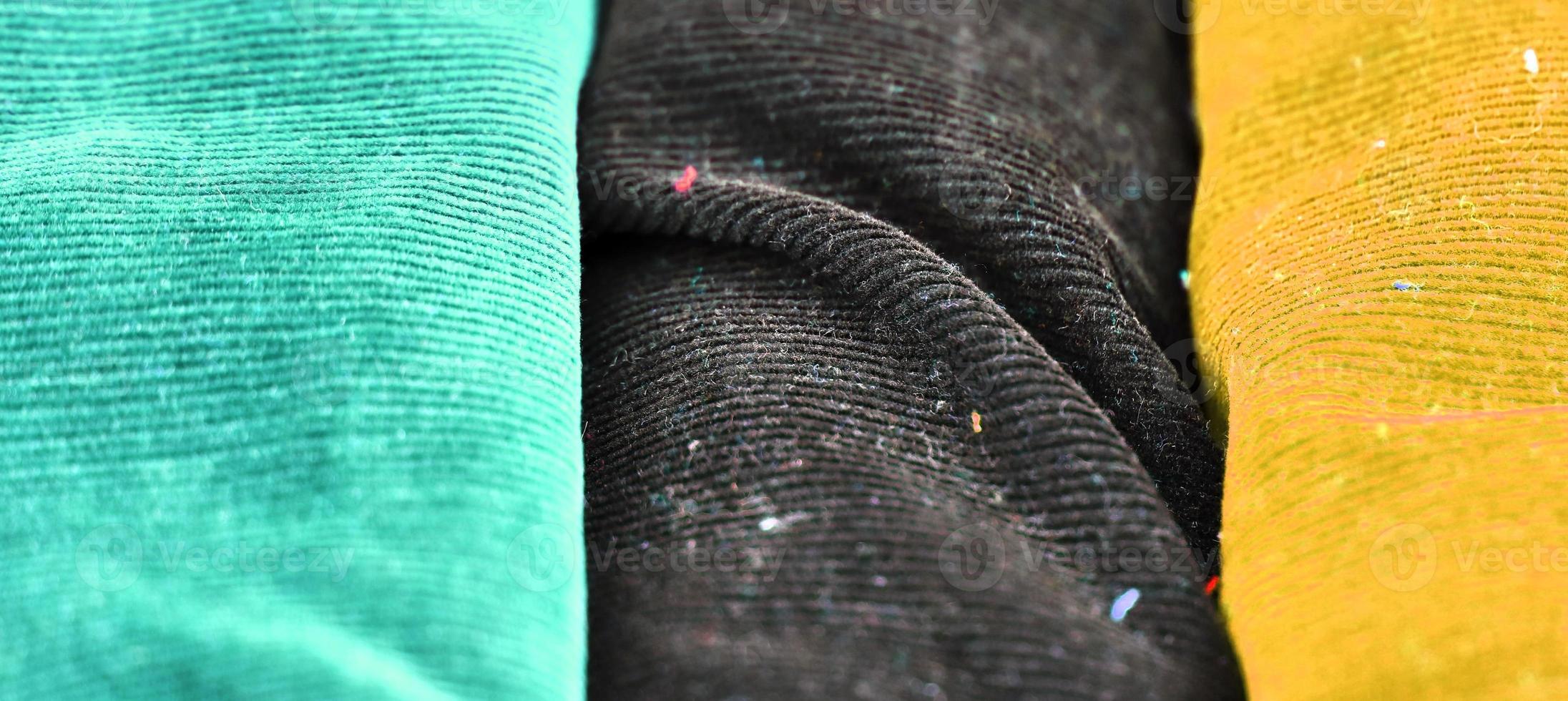 Detailed close up view on samples of cloth and fabrics in different colors found at a fabrics market photo