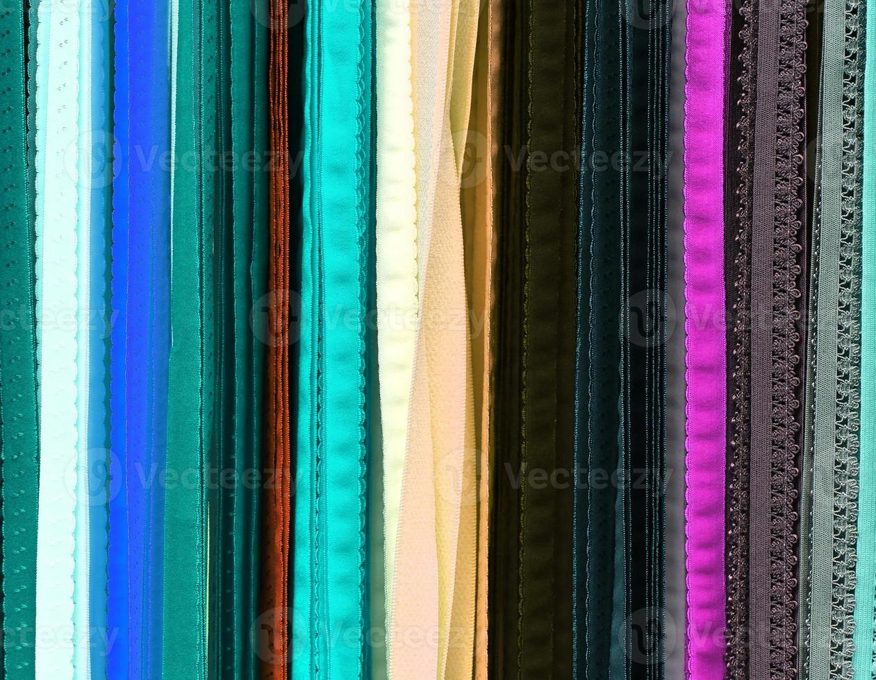Detailed close up view on samples of cloth and fabrics in different colors found at a fabrics market photo