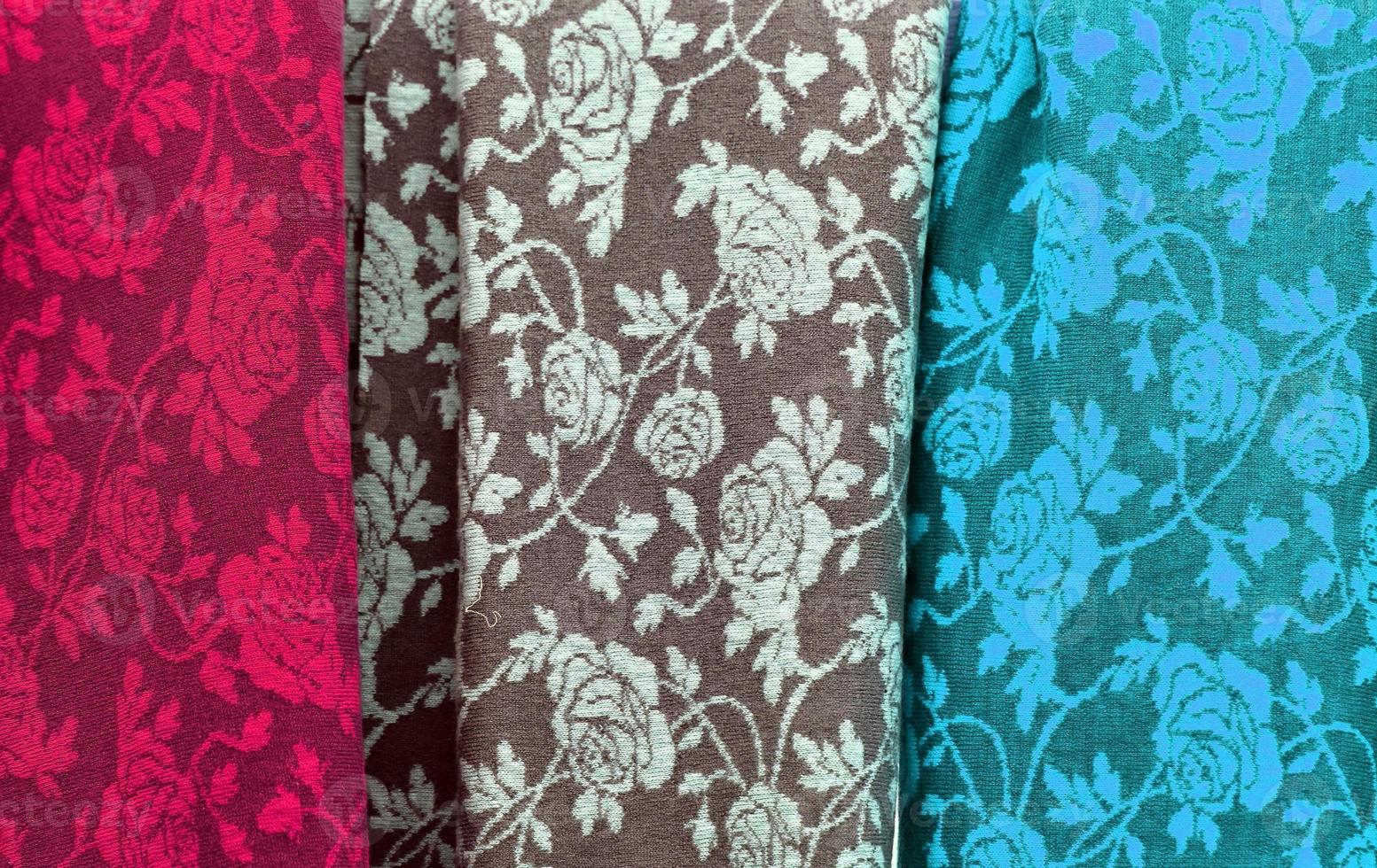 Detailed close up view on samples of cloth and fabrics in different colors found at a fabrics market photo