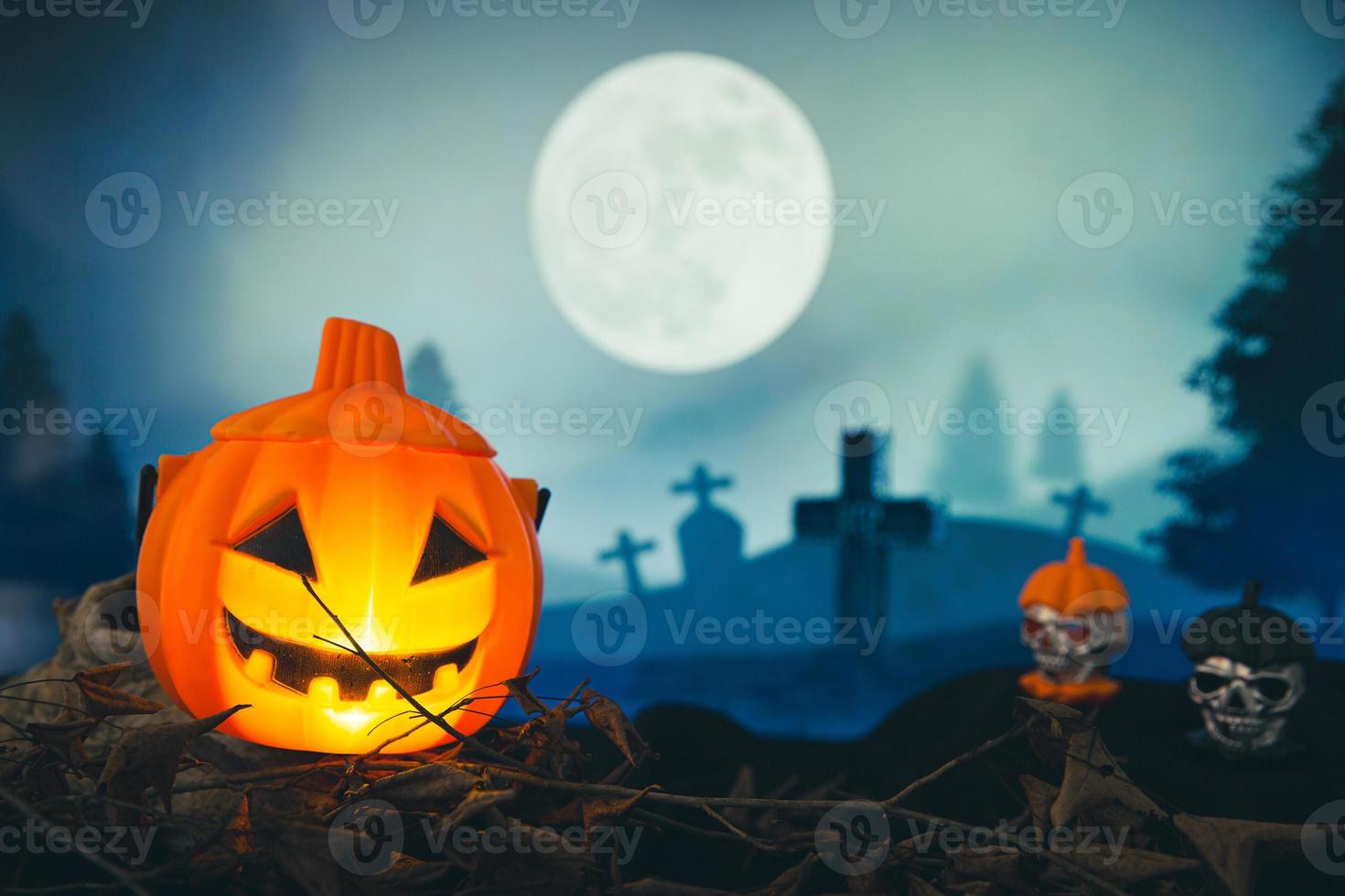 Spooky cemetery with glow halloween pumpkin photo