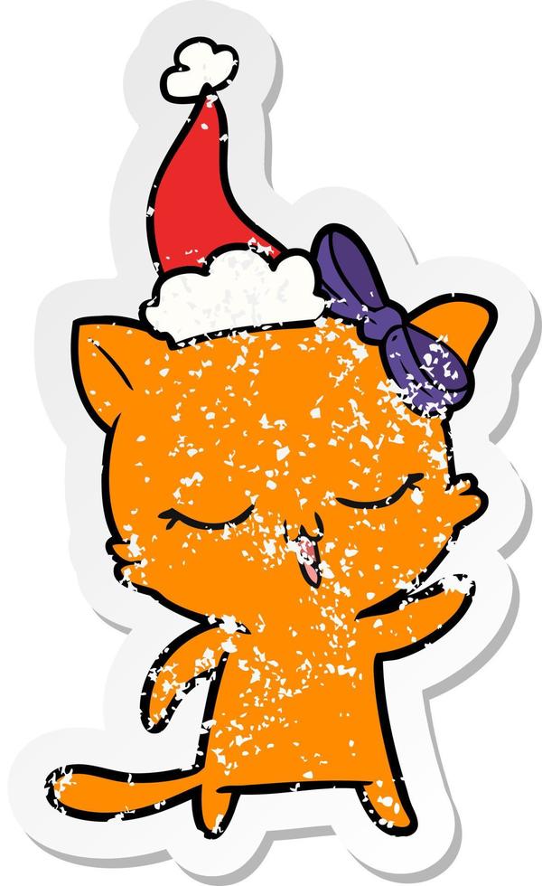 distressed sticker cartoon of a cat with bow on head wearing santa hat vector