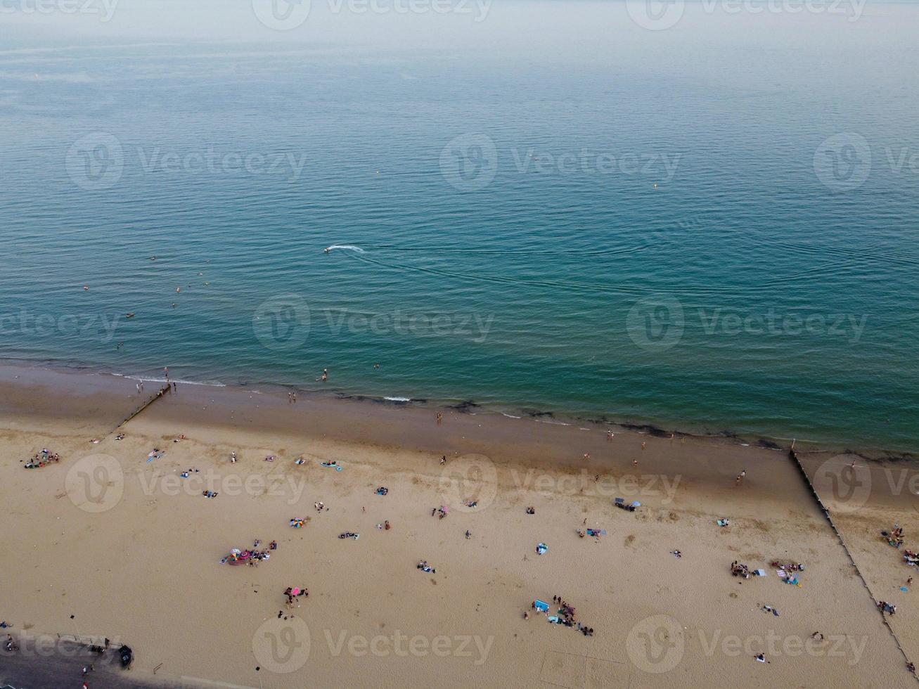 Frente a la playa con vistas al mar en ángulo alto con gente en la ciudad de Bournemouth, Inglaterra, Reino Unido, imágenes aéreas del océano británico foto