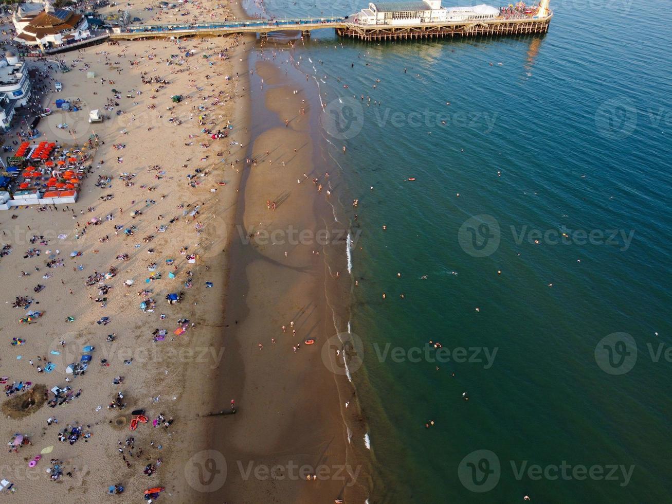 Frente a la playa con vistas al mar en ángulo alto con gente en la ciudad de Bournemouth, Inglaterra, Reino Unido, imágenes aéreas del océano británico foto