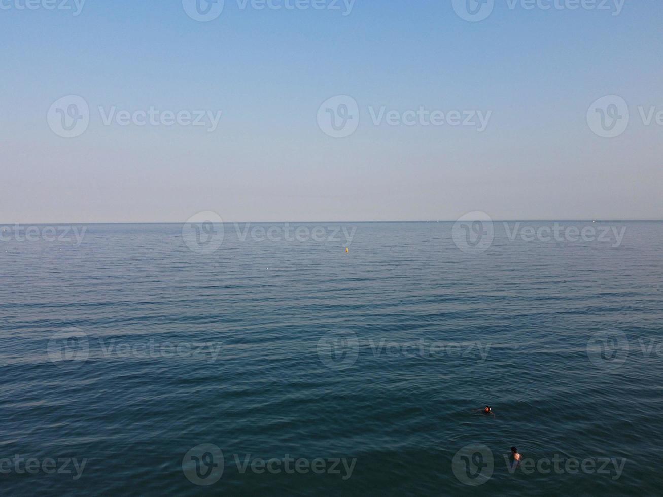 imágenes de alto ángulo y vista aérea del océano con botes de alta velocidad, la gente se divierte y disfruta del clima más cálido en la playa de bournemouth, frente al mar en inglaterra, reino unido. foto