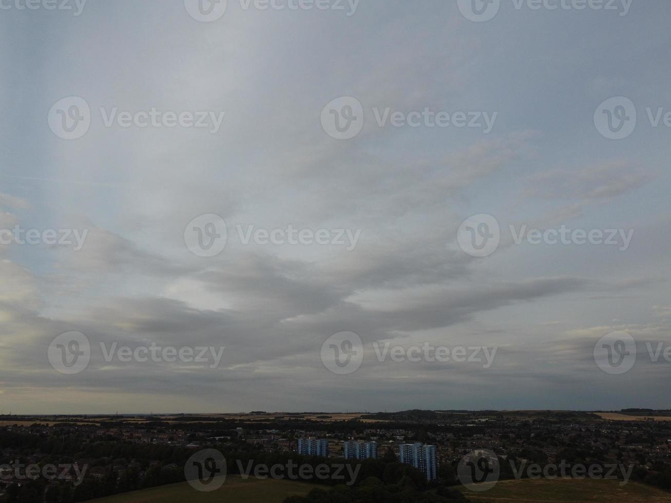 Beautiful Sunset over British Town, Colourful Sky with yellow, orange and black clouds over light blue sky photo