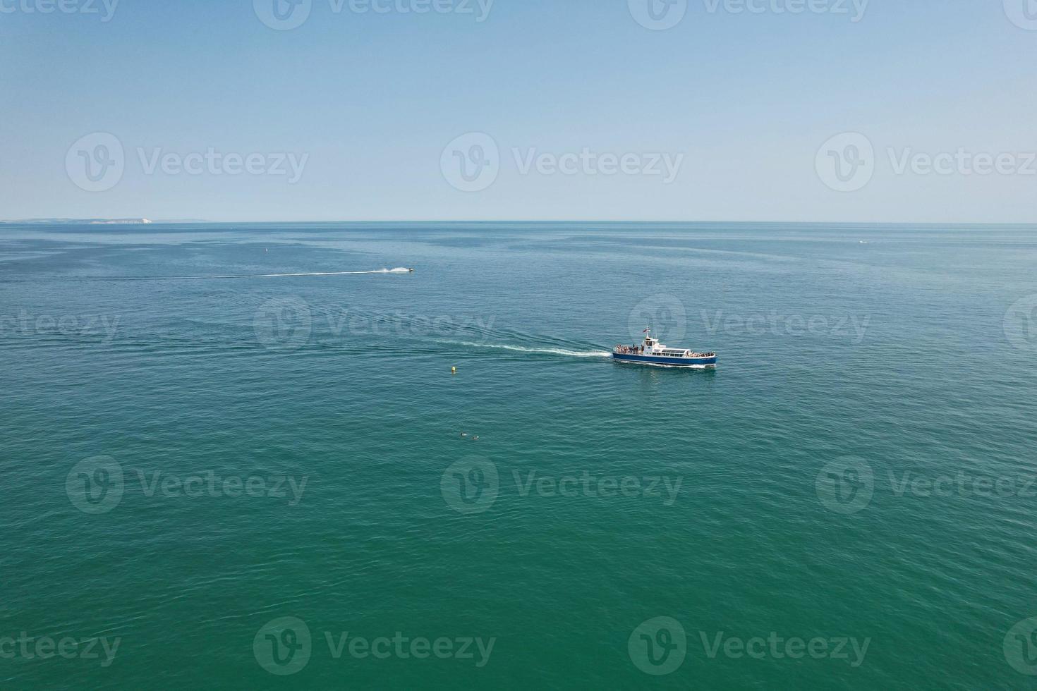 High Angle Footage and Aerial view of Ocean with High Speed Boats, People are having fun and enjoying hottest weather at Bournemouth Beach Sea Front of England UK. photo