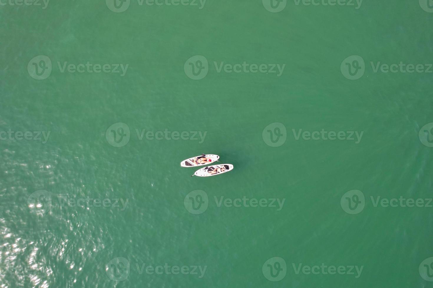 High Angle Footage and Aerial view of Ocean with High Speed Boats, People are having fun and enjoying hottest weather at Bournemouth Beach Sea Front of England UK. photo