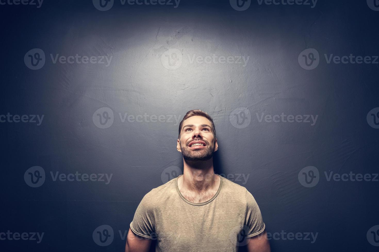 Attractive, smiling man leaning against the wall. photo