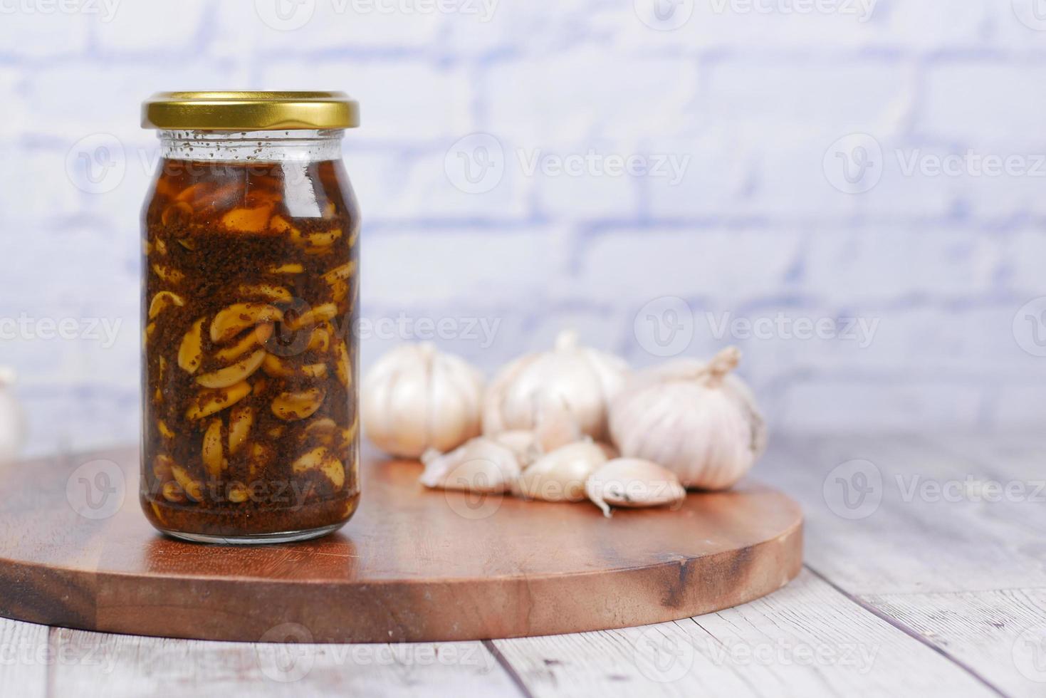 Homemade Garlic Pickle in a glass jar on table , photo