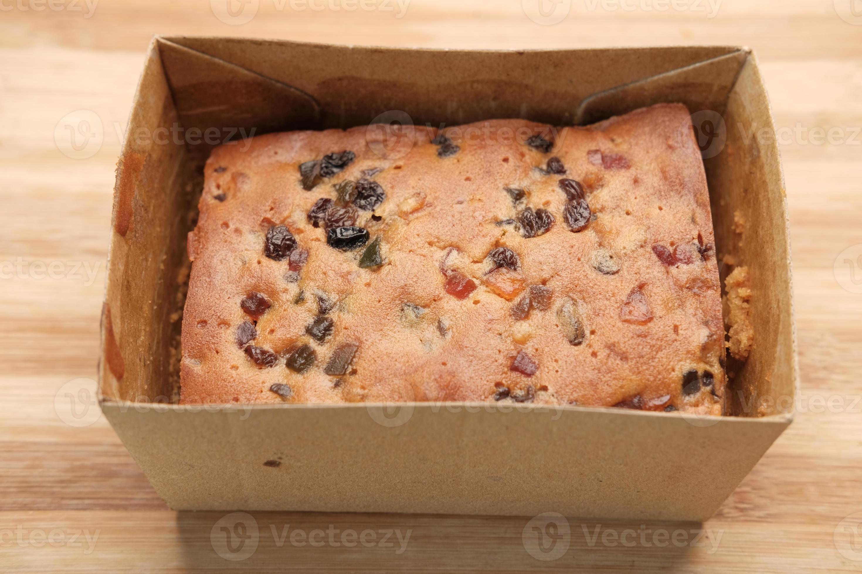 slice of bakery fruit cake in a paper packet on table 10277497 Stock