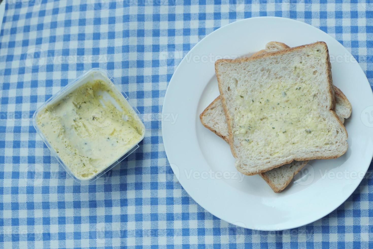 mantequilla de ajo untada en un pan en la mesa foto