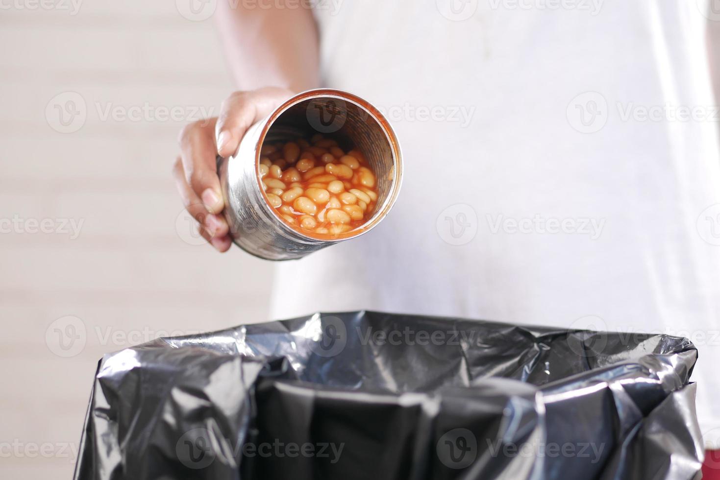 throwing tin container in a garbage bin photo