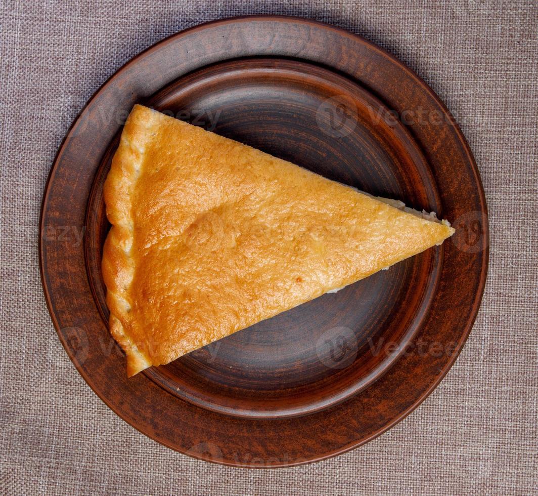 A triangular piece of cake on a ceramic dish. Top view. photo