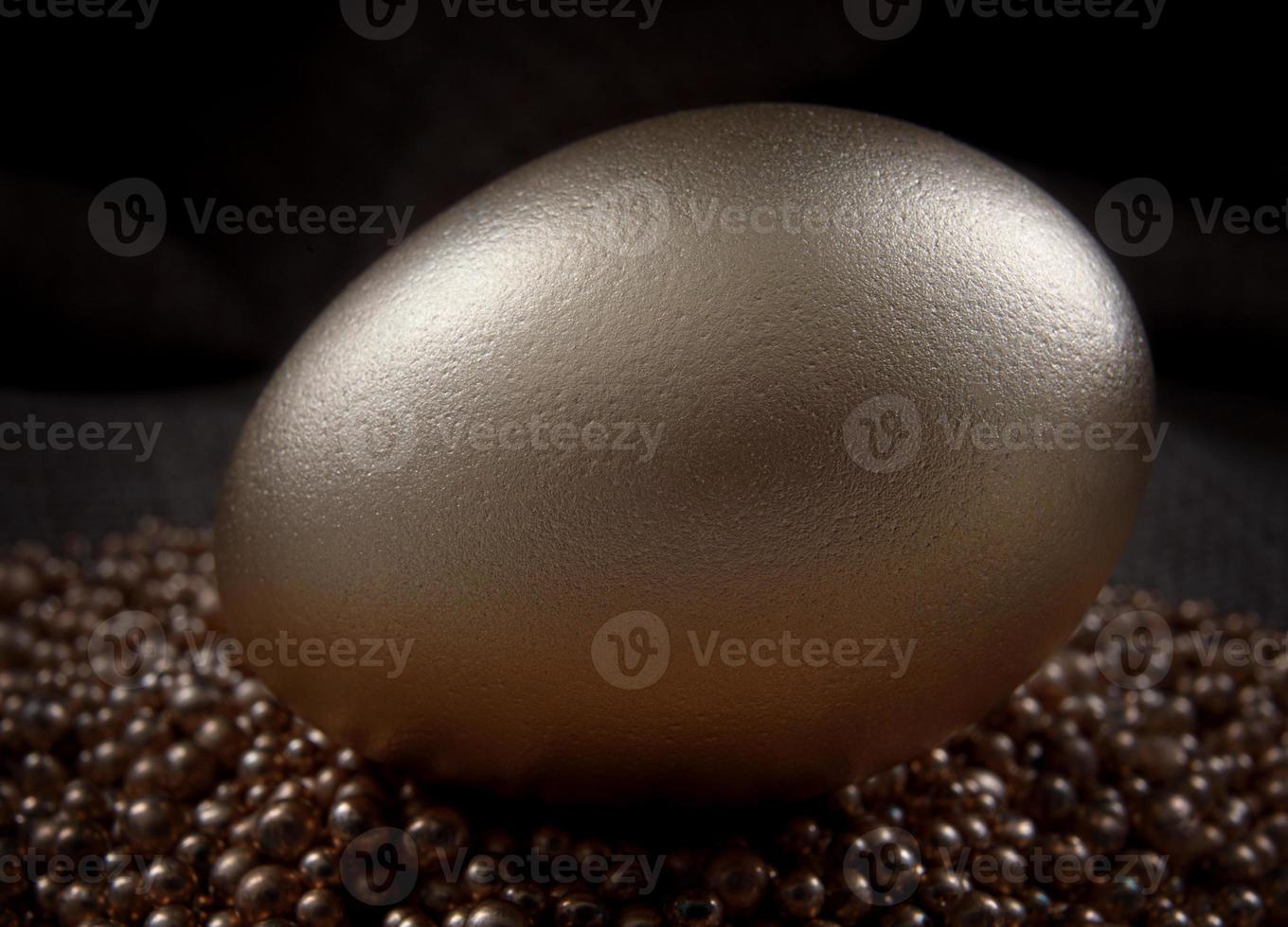 The golden egg lies on the gold sand. photo