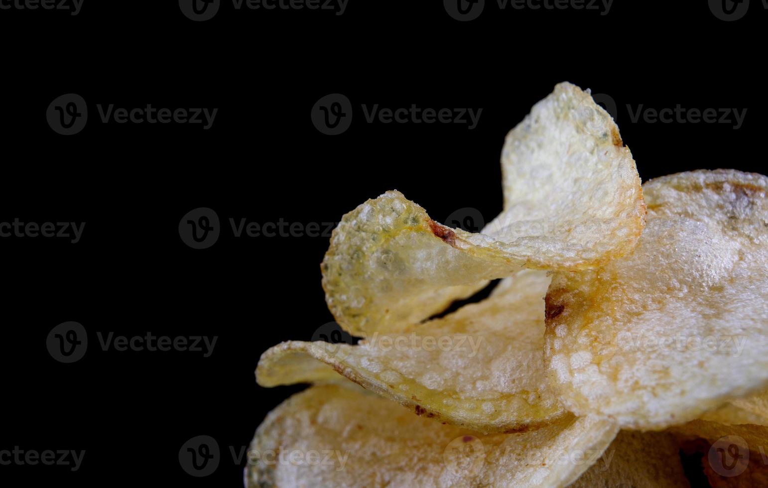 Potato chips on a black background. crispy potato chips. photo