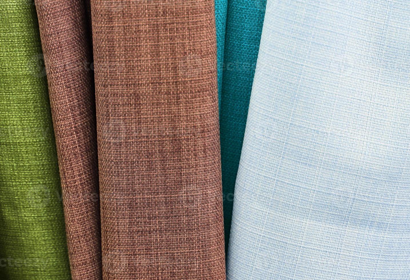 Detailed close up view on samples of cloth and fabrics in different colors found at a fabrics market photo