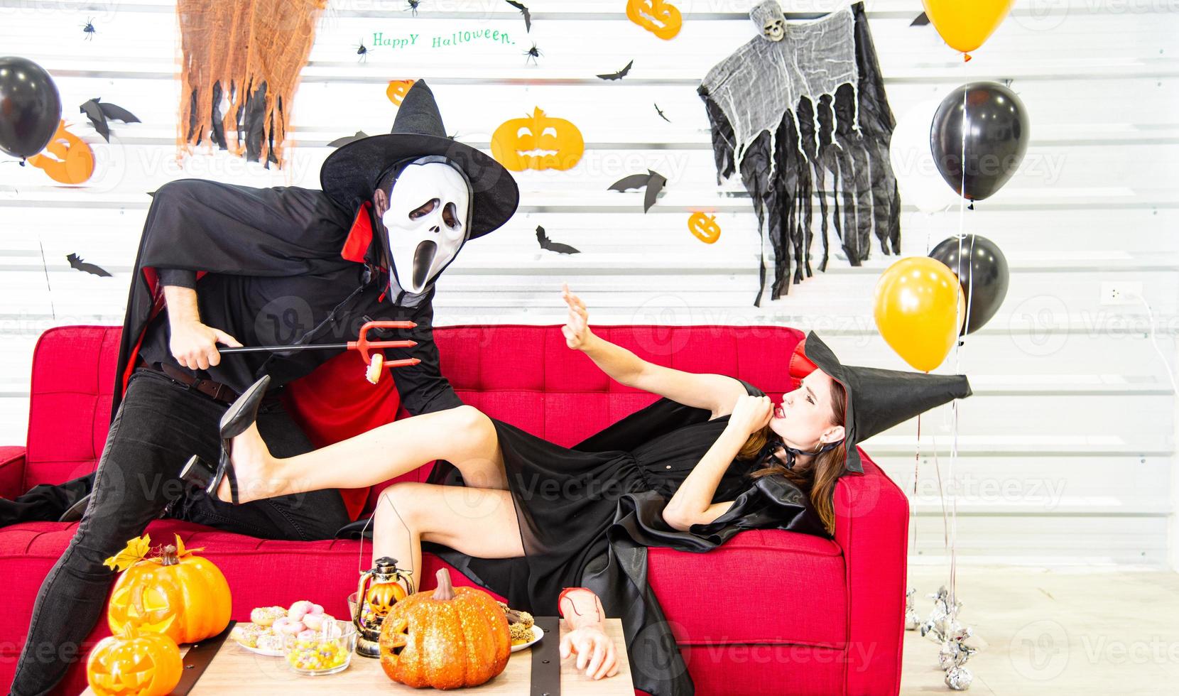 Happy Halloween party concept. Young man and woman wearing as vampires, witch or ghost celebrate the halloween festival photo