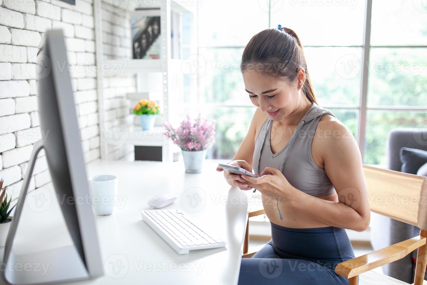joven mujer asiática que usa una computadora portátil revisando la aplicación de medios sociales en el sitio web en línea en casa, siéntase relajada y disfrute comunicándose y discutiendo en la sala de estar. foto