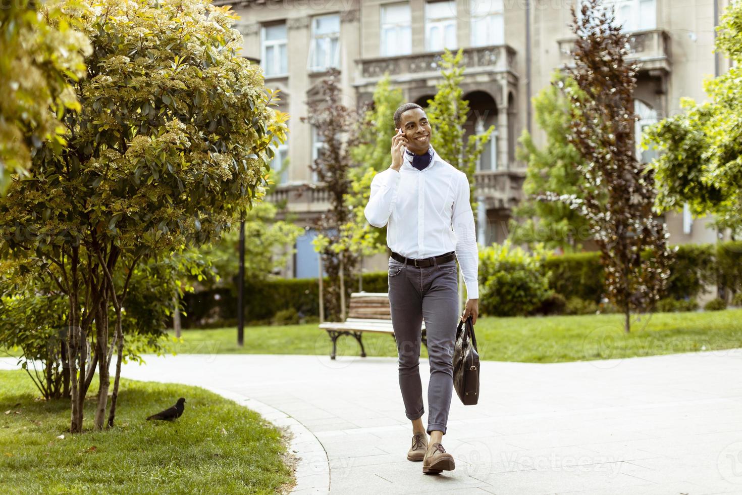 Young African American businessman using a mobile phone on a street photo